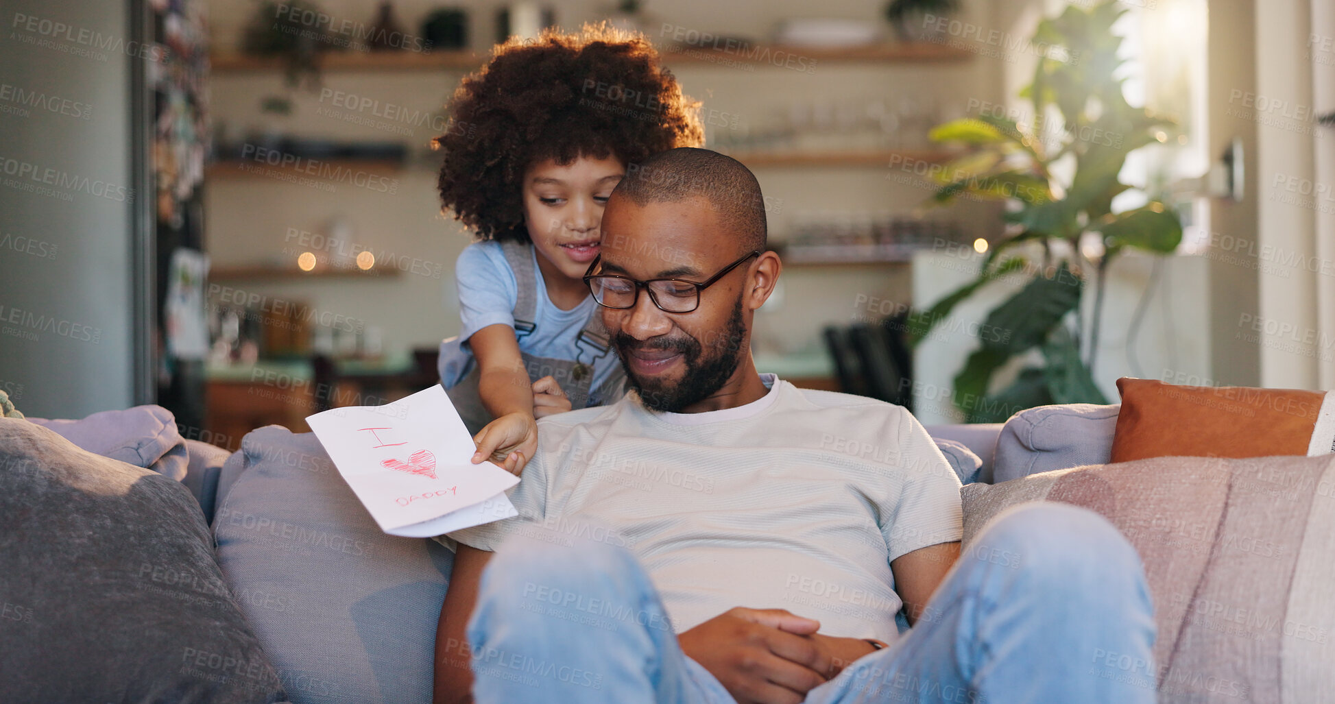 Buy stock photo Card, surprise and dad with child in home for fathers day celebration with bonding together. Happy, relax and black man with boy kid with care for drawing gift on sofa in living room at family house.