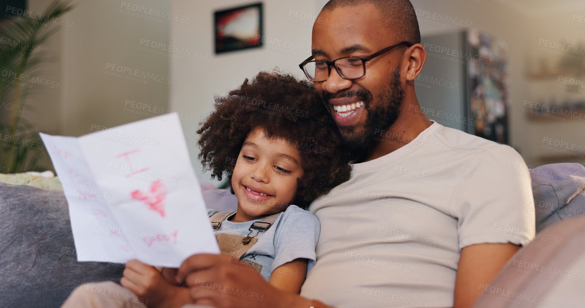 Buy stock photo Card, relax and dad with child in home for fathers day celebration with bonding together. Happy, love and black man hugging boy kid with care for drawing gift on sofa in living room at family house.