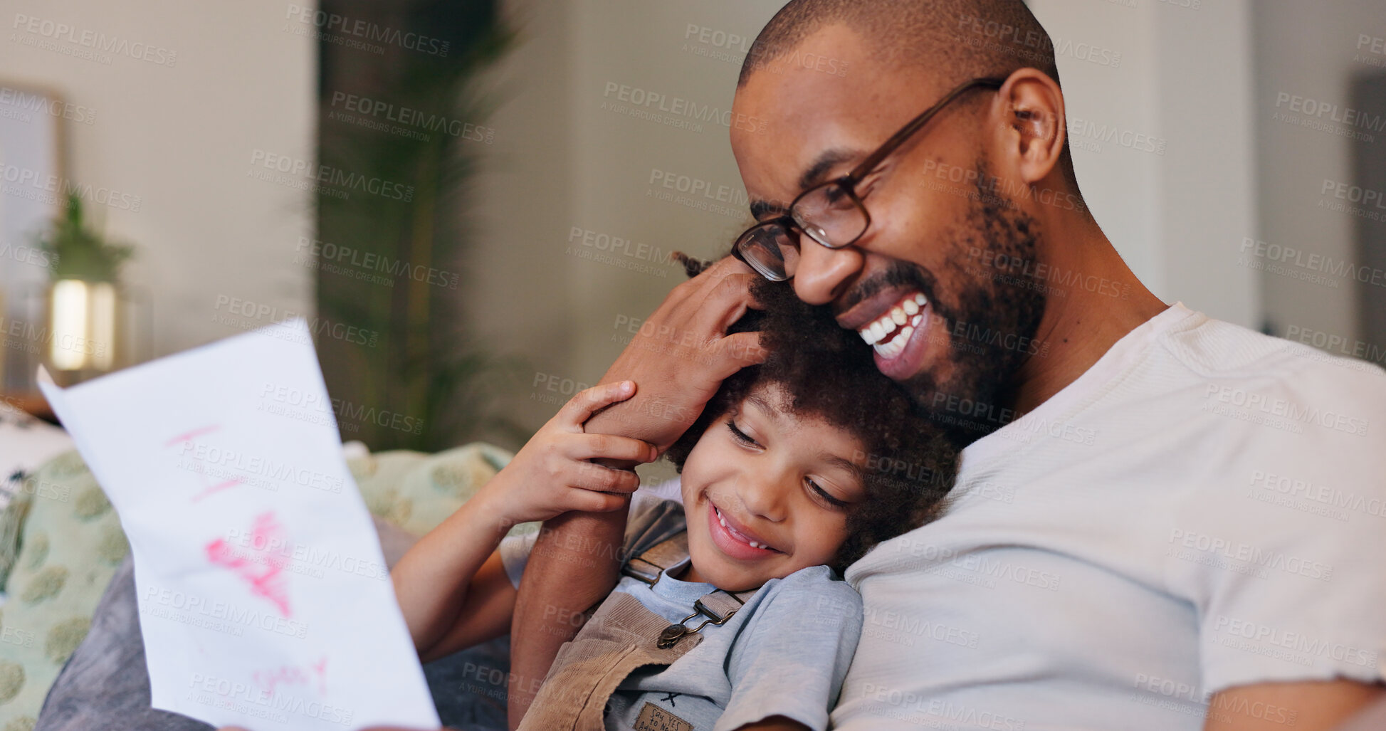 Buy stock photo Card, relax and dad with kid in home for fathers day celebration with bonding together. Happy, love and black man hugging boy child with care for drawing gift on sofa in living room at family house.