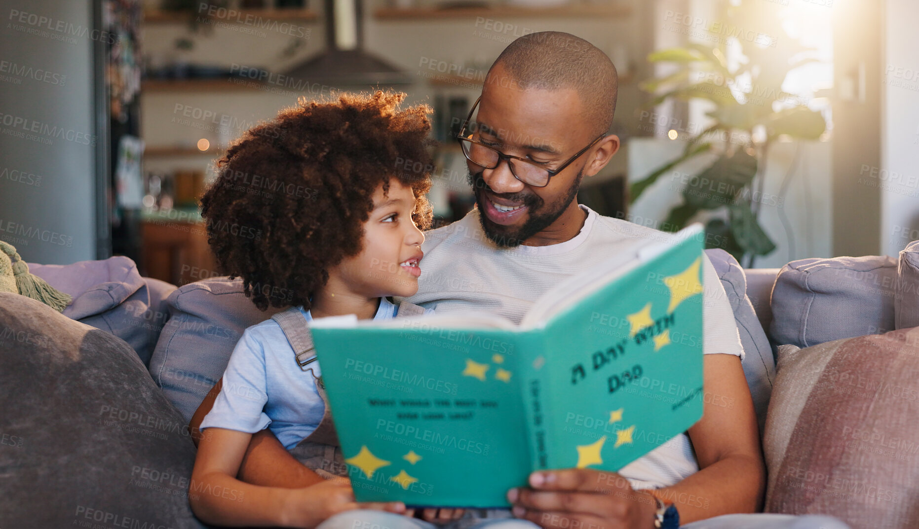 Buy stock photo African man, son and reading story book on couch, listening and bonding in morning at family house. Father, boy and smile with care, fantasy and relax with love, literature or learning in living room