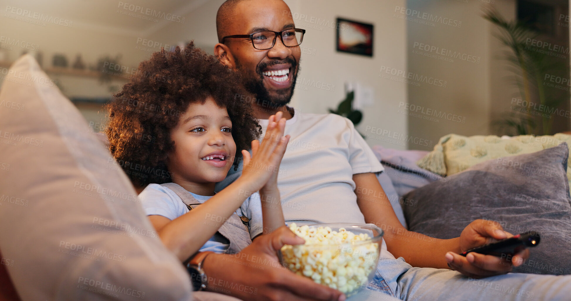 Buy stock photo Father, boy and smile with television or popcorn on sofa in living room for movies, cartoon and entertainment. People, parent and happy with kid at home for streaming platform with child development