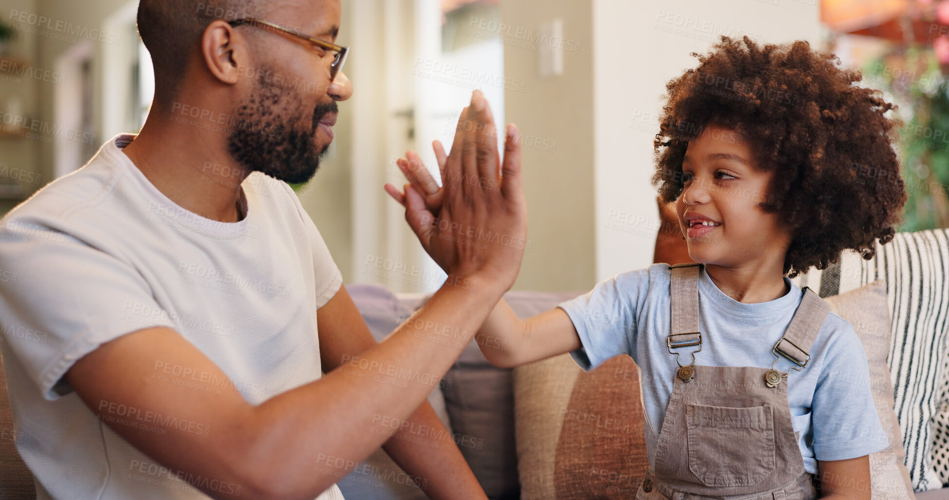 Buy stock photo Happy father, teamwork and high five with son for achievement, victory or bonding together at home. Dad, young child or little boy touching with smile for winning, congratulations or good job on sofa