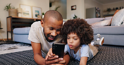 Buy stock photo Happy dad, child and floor with phone for streaming, entertainment or social media at home. Father, son or little boy lying on living room carpet on mobile smartphone for online browsing or games