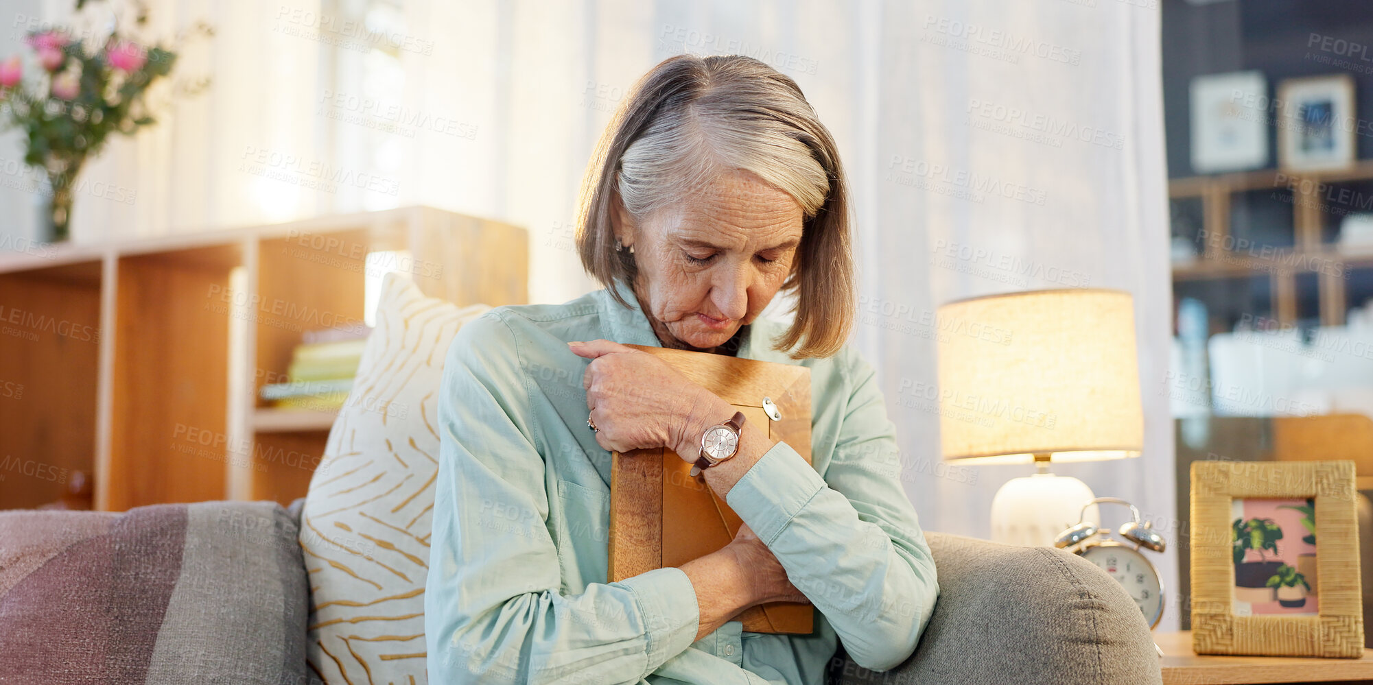 Buy stock photo Senior woman, picture and sad with grief for mourning, memory and remember past life in nursing home. Elderly widow, hug and photo frame for depression with mental health, nostalgia and retirement