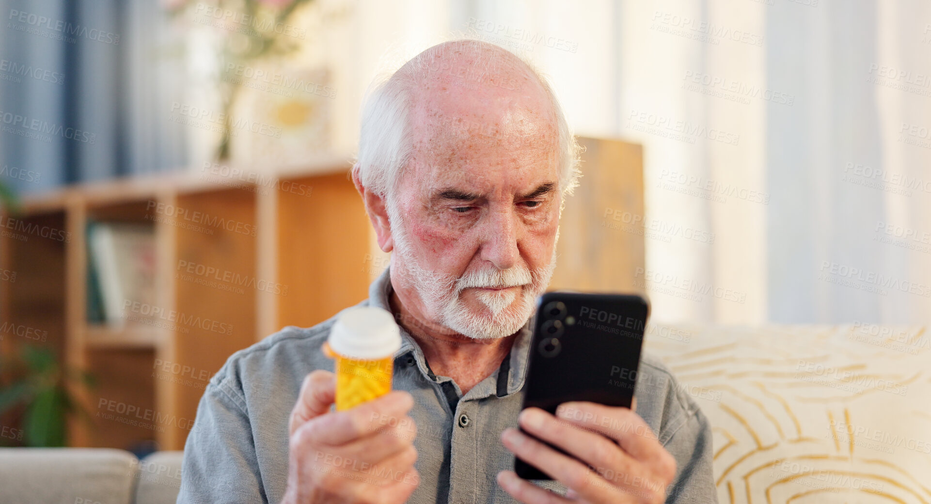 Buy stock photo Home, pills and elderly man with phone for healthcare information, advice and research on medicine. Retirement, telehealth and senior person with container for side effects, dosage or reading website