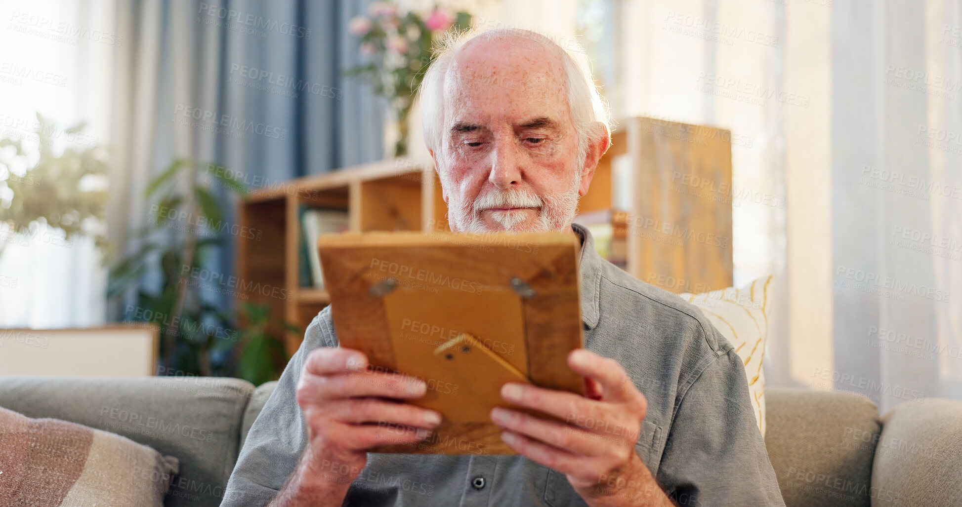 Buy stock photo Retirement, senior man and frame with nostalgia, memories and reflection of past with picture on sofa. Home, old person and remember with wooden album, photo or cognitive trigger with journey of life