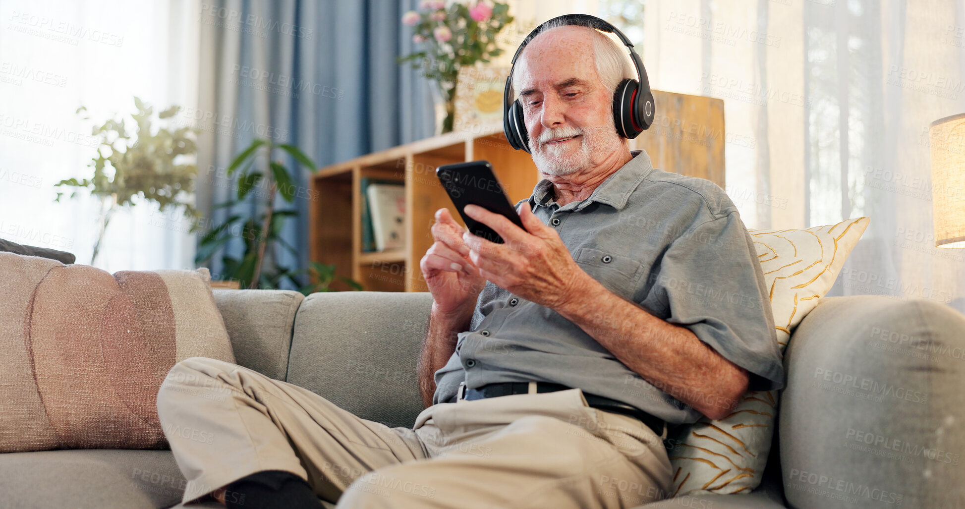 Buy stock photo Phone, headphones and senior man on sofa for streaming music with retirement, jazz playlist and relax in home. Elderly person, mobile and listening to podcast for entertainment, online audio or radio