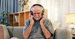 Retirement home, senior man and happy with headphones for music, playlist and online radio. Sofa, living room and smile with earphones to relax as pensioner for fun, entertainment and audio or song