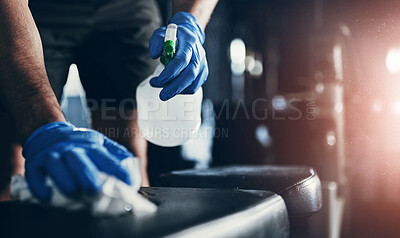 Buy stock photo Cropped shot of an unrecognisable man disinfecting the surfaces in a gym