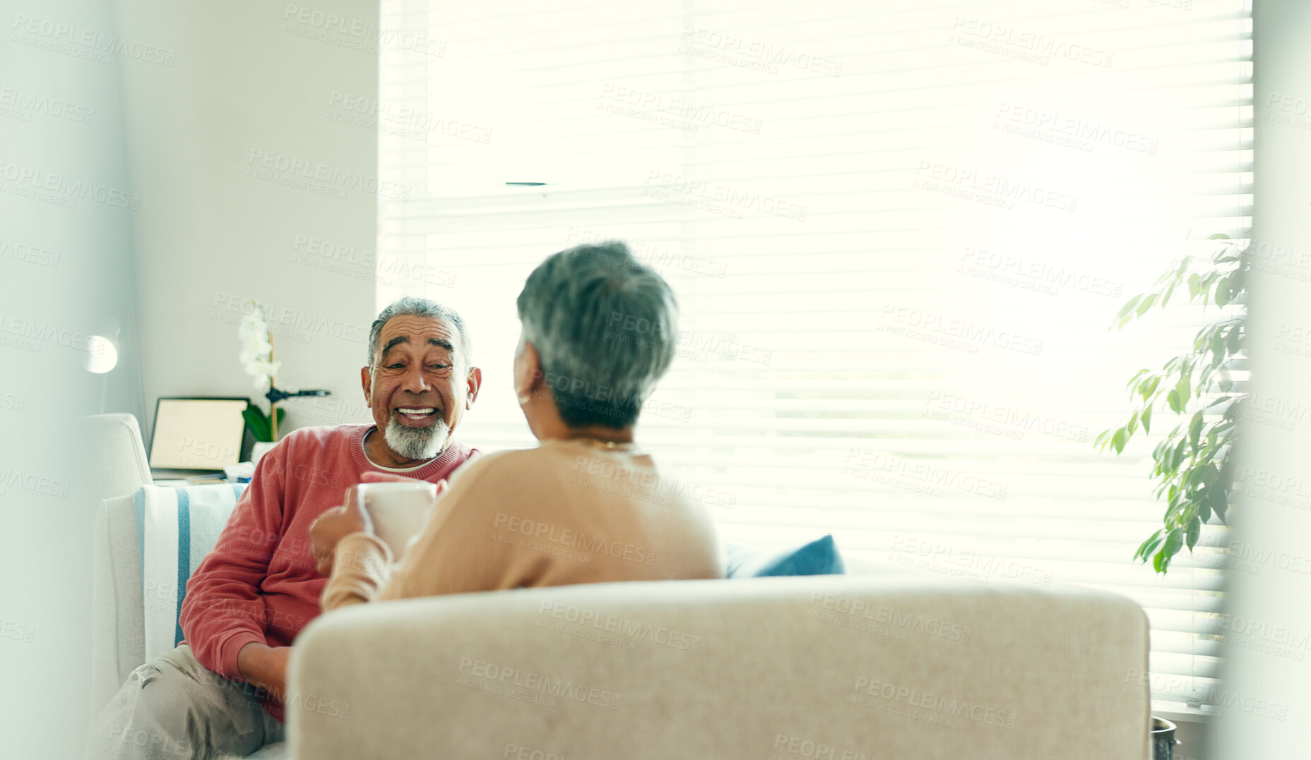 Buy stock photo Tea time, happy and elderly couple in living room for love, story telling and bonding at home. Senior man, woman and relax on sofa with talking, nostalgia and commitment or support in retirement