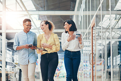 Buy stock photo Shot of a group of young businesspeople having a discussion while walking through a modern office