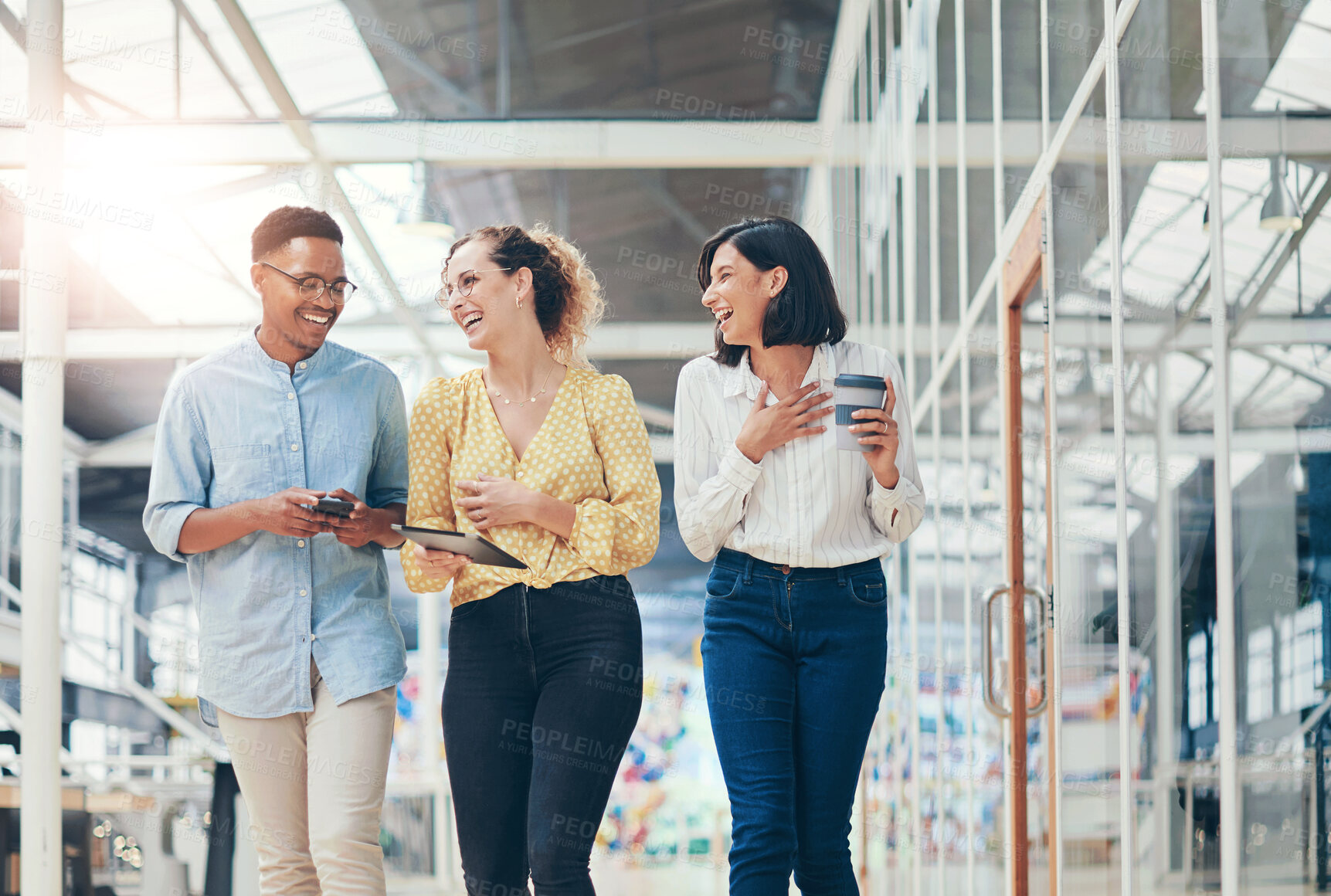 Buy stock photo Shot of a group of young businesspeople having a discussion while walking through a modern office