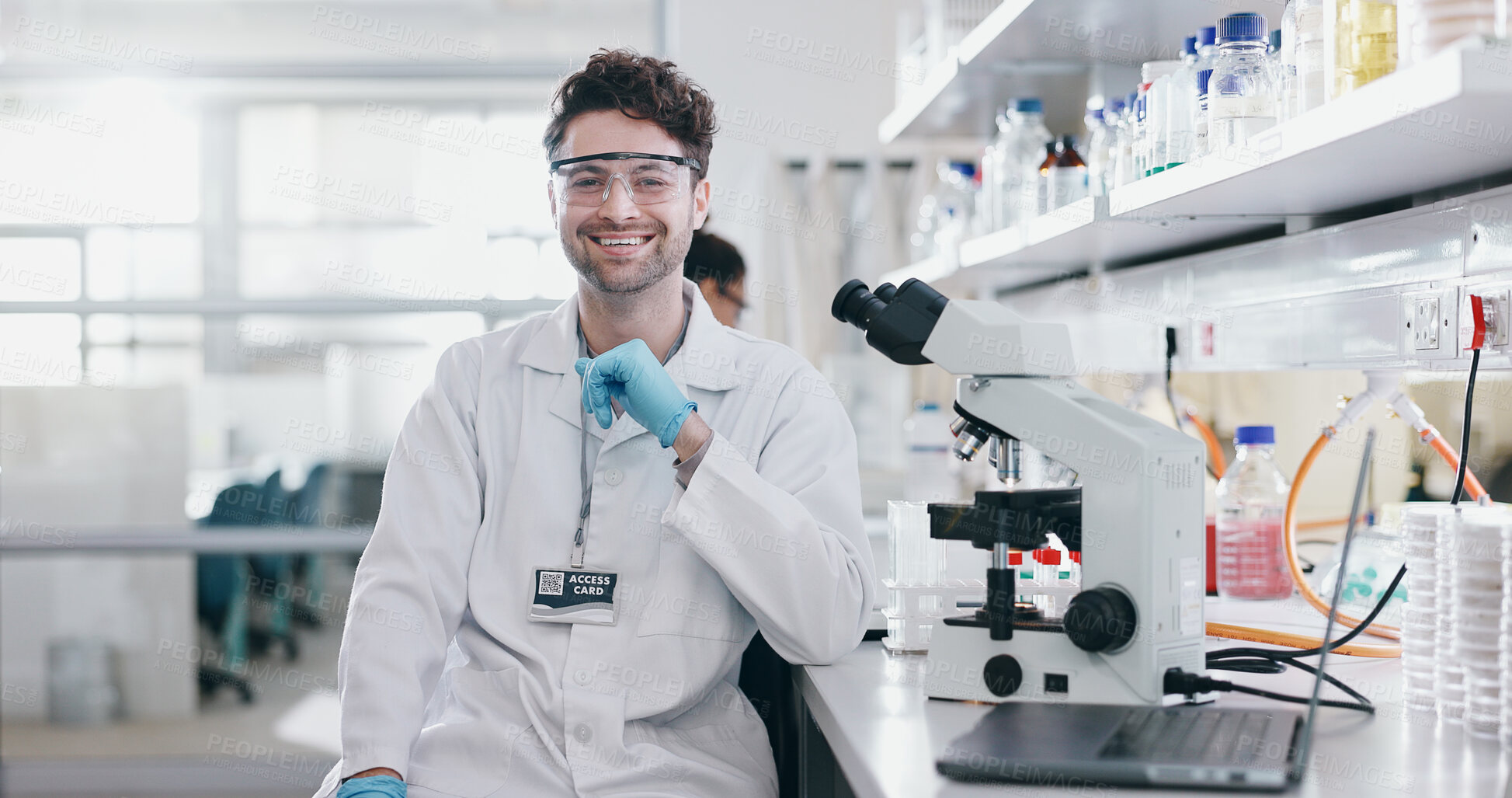 Buy stock photo Portrait, science and smile of man on microscope in lab to research chemistry, test or innovation. Laptop, scientist and face of medical doctor in goggles for microbiology, healthcare or pharma study