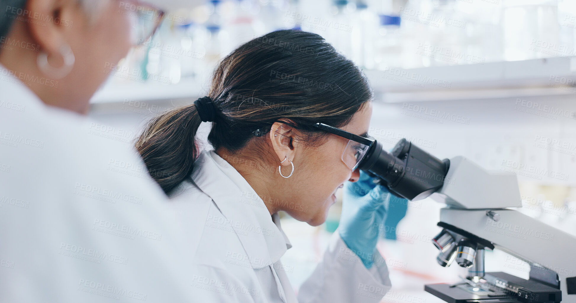 Buy stock photo Medical, research and women with microscope, science and check experiment for cancer treatment. People, scientist and employee with lab equipment, mentor or cure development with coaching or teamwork