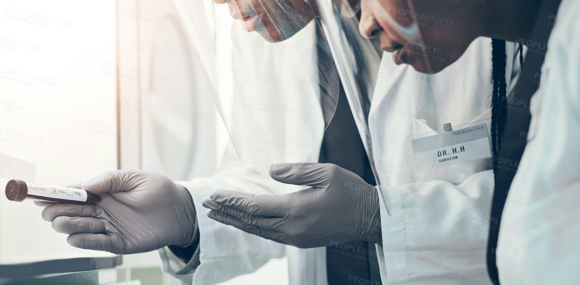 Buy stock photo Shot of two scientists wearing face shields while working together in a lab