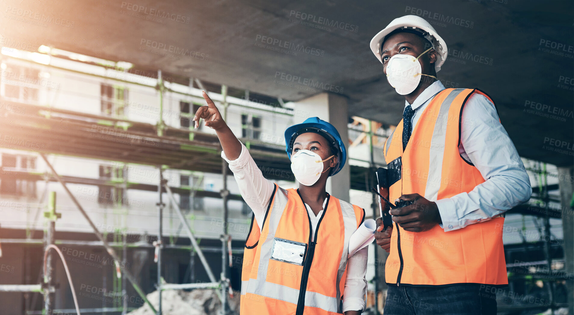 Buy stock photo Shot of a young man and woman having a discussion while working at a construction site