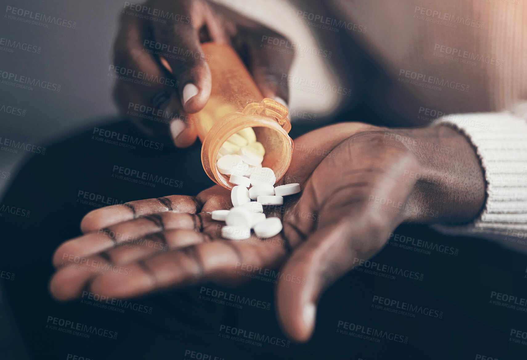 Buy stock photo Cropped shot of an unrecognizable man sitting alone and taking pills out of a pill bottle in his living room