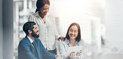 Buy stock photo Shot of a group of businesspeople working together on a digital tablet in an office