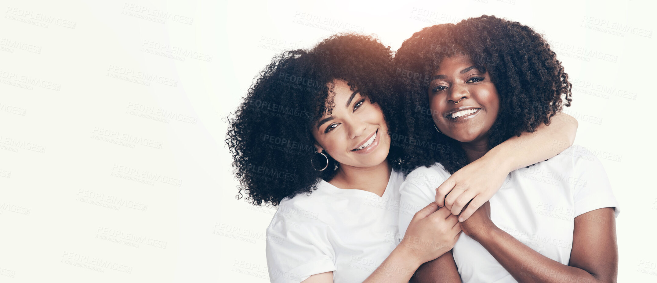 Buy stock photo Studio shot of two young women embracing each other against a white background