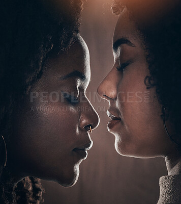 Buy stock photo Cropped shot of a beautiful young female couple posing in studio against a dark background