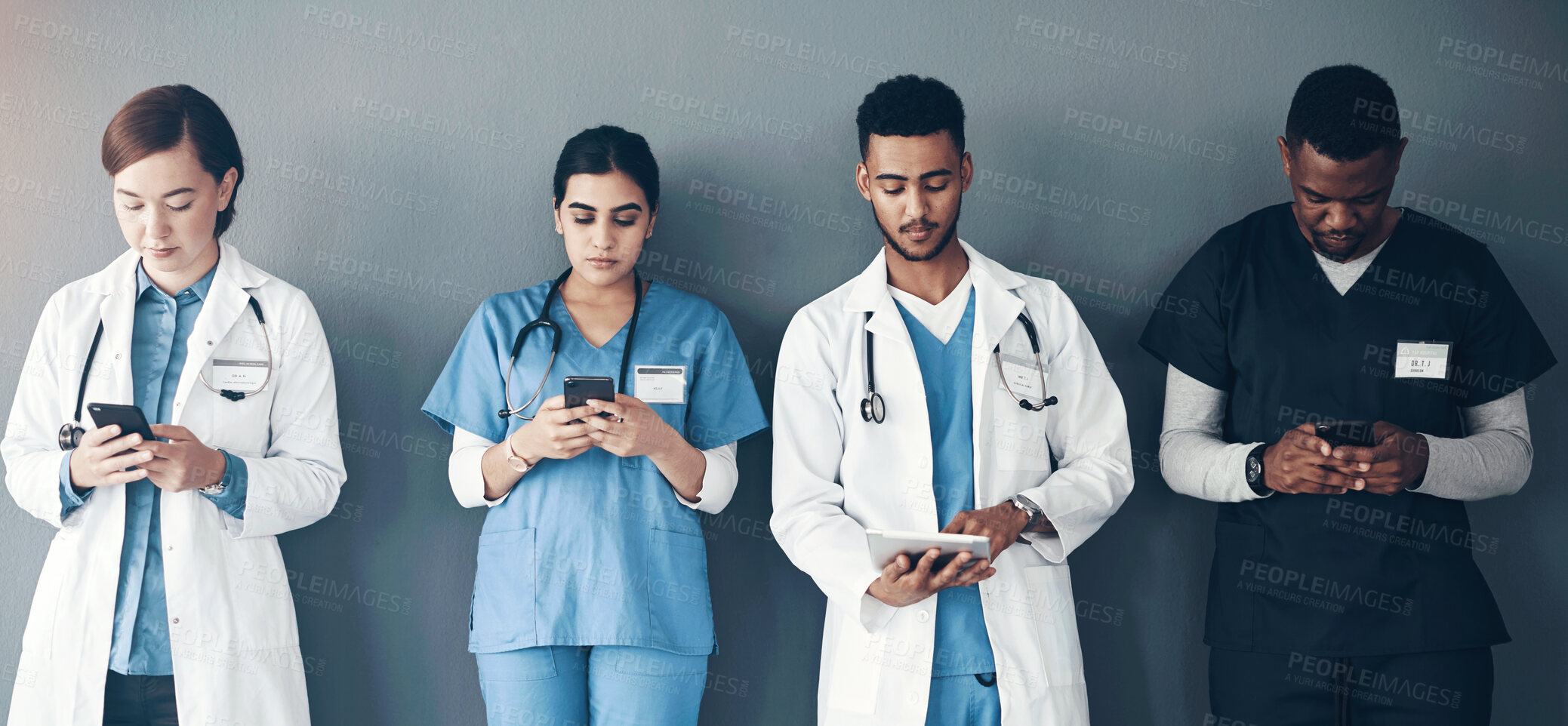 Buy stock photo Doctor, team and waiting room with phone in row for medical research or communication on a wall background. Group, people or colleagues with technology or mobile smartphone in line for health network