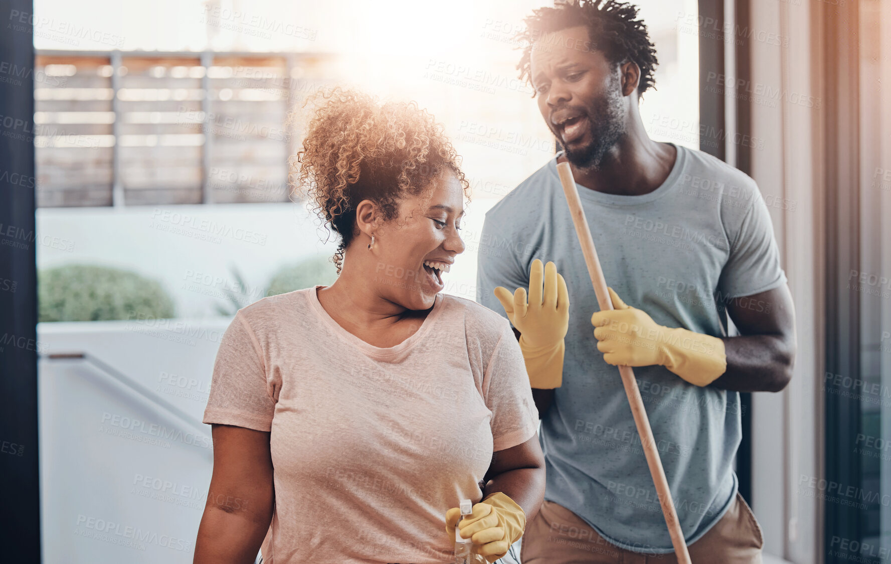 Buy stock photo Shot of a young couple singing while cleaning at home