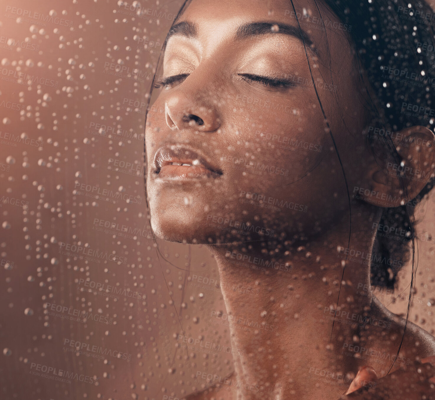 Buy stock photo Portrait of a beautiful young woman having a refreshing shower against a brown background