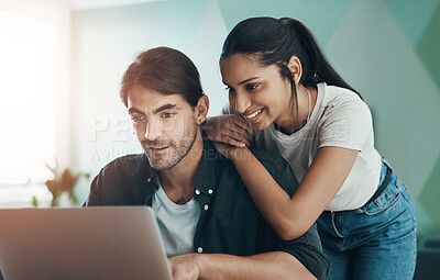 Buy stock photo Shot of a young couple doing paperwork while using a laptop at home