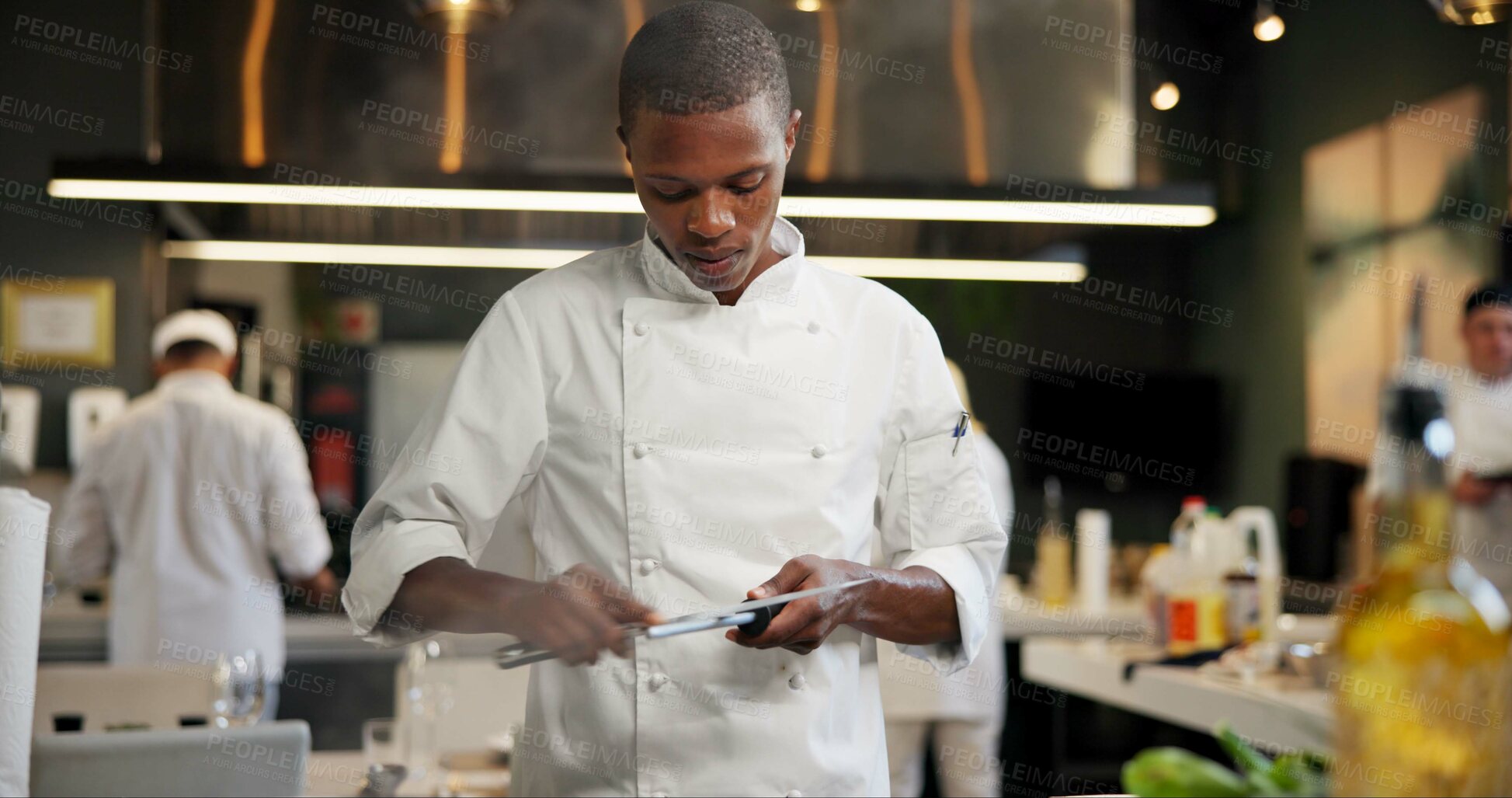 Buy stock photo Black man, chef and serious with knife sharpener in kitchen at restaurant for fine dining, veg and creativity. Male employee, professional and cooker with food for culinary, hospitality and catering