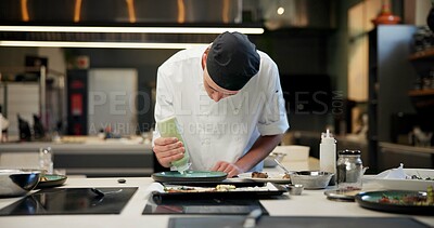 Buy stock photo Man, chef and plate with sauce in kitchen at restaurant for fine dining, meal and creativity. Male employee, professional and cooker with food for culinary, hospitality and catering service