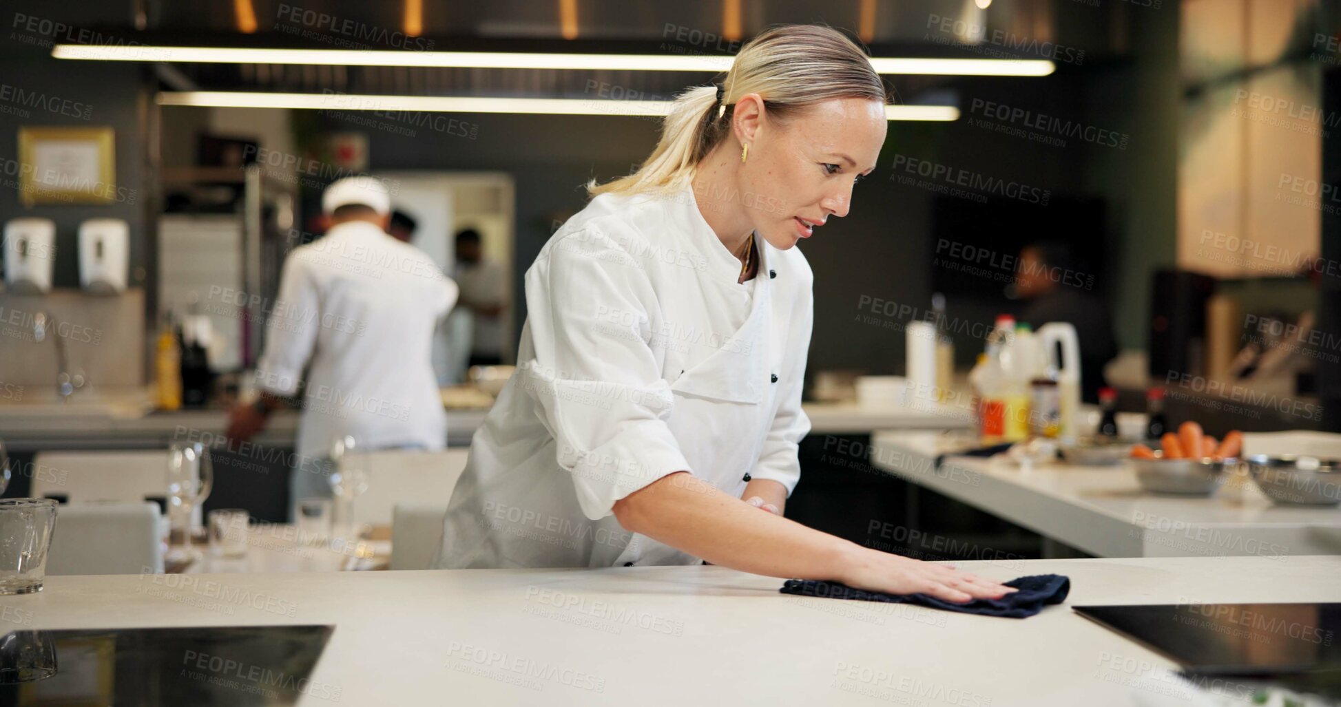 Buy stock photo Woman, cleaning and chef wipe counter for dinner rush prep, hygiene and bacteria removal. Dust, person and employee in kitchen, cloth or restaurant with sanitation, disinfection or hospitality policy