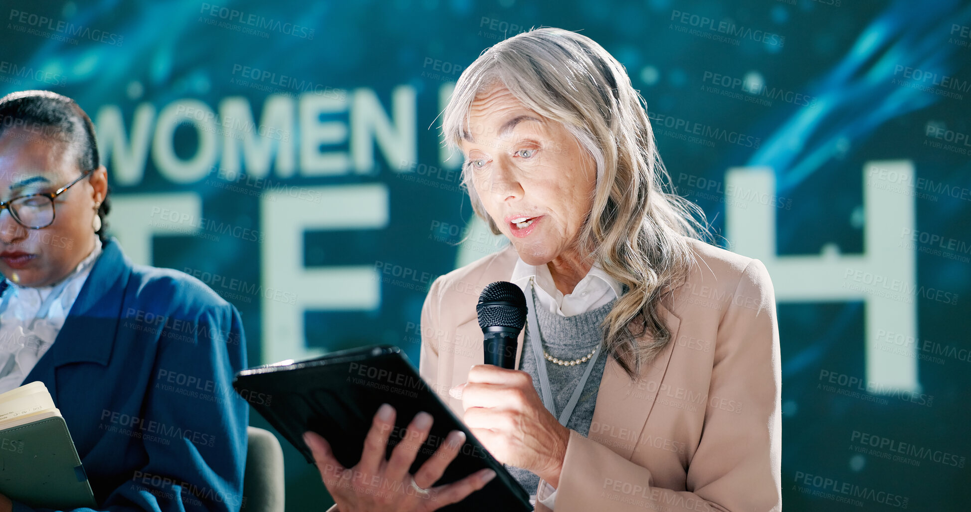 Buy stock photo Talking, seminar and woman on stage, speaker and motivation for gender equality, leadership and speech. Tablet, online and presentation for female employees in technology, mic and person in group