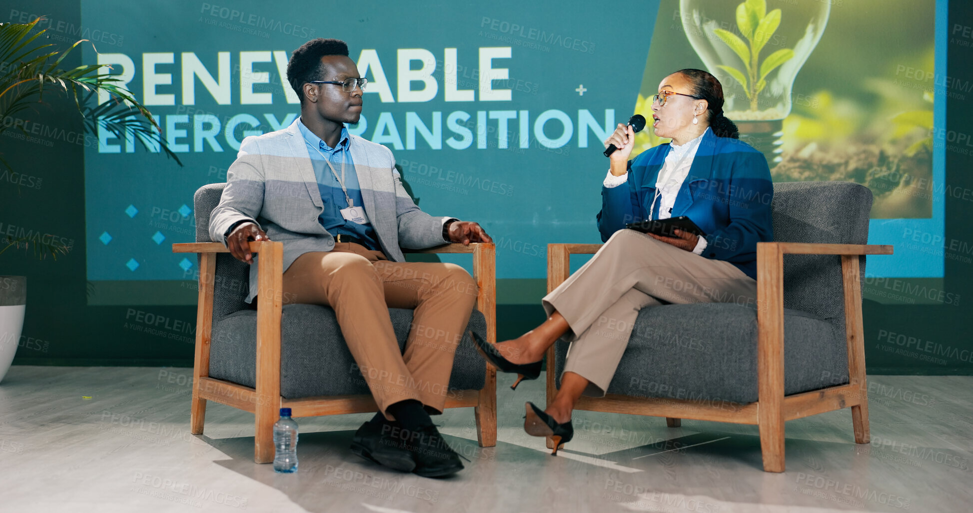 Buy stock photo Man, woman and discussion on stage at conference for renewable energy, solution and global policy. People, questions and talk in public debate for sustainability, future or plan of action for planet