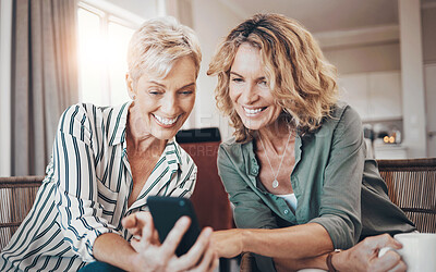 Buy stock photo Shot of two female friends drinking coffee while using a digital tablet