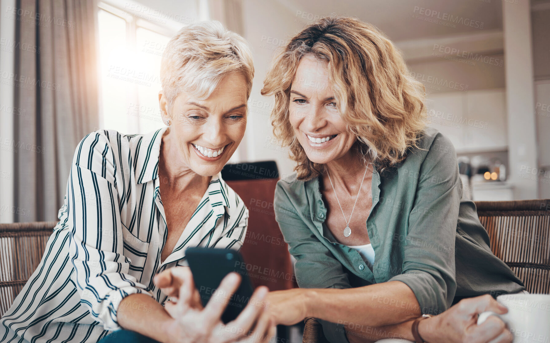 Buy stock photo Shot of two female friends drinking coffee while using a digital tablet