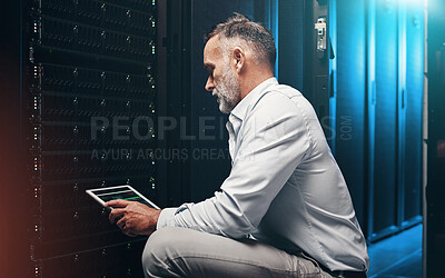 Buy stock photo Shot of a mature man using a digital tablet while working in a server room