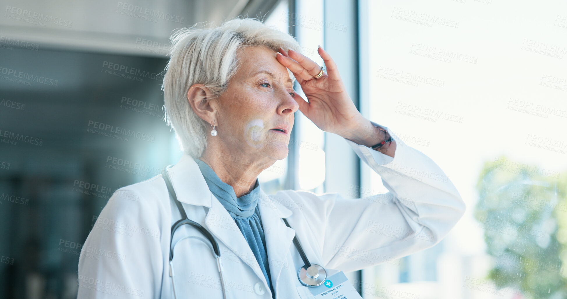 Buy stock photo Mature woman, doctor and headache in grief, burnout or mistake against glass window in hospital building. Frustrated physician, medical healthcare and person in stress, loss or fatigue at clinic