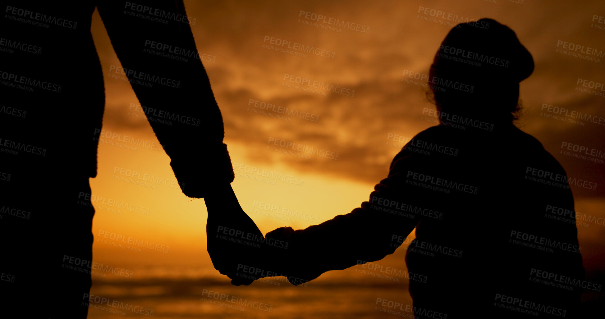 Buy stock photo Holding hands, sunset and silhouette of parent and child by beach on vacation, holiday or adventure. Love, travel and shadow of person with kid for connection by ocean on tropical weekend trip.