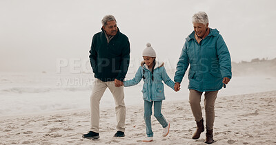 Buy stock photo Grandparents, child and beach with holding hands, walking and together on vacation by the sea. Love, smile and happy girl with senior people outdoor in winter on holiday with retirement and travel