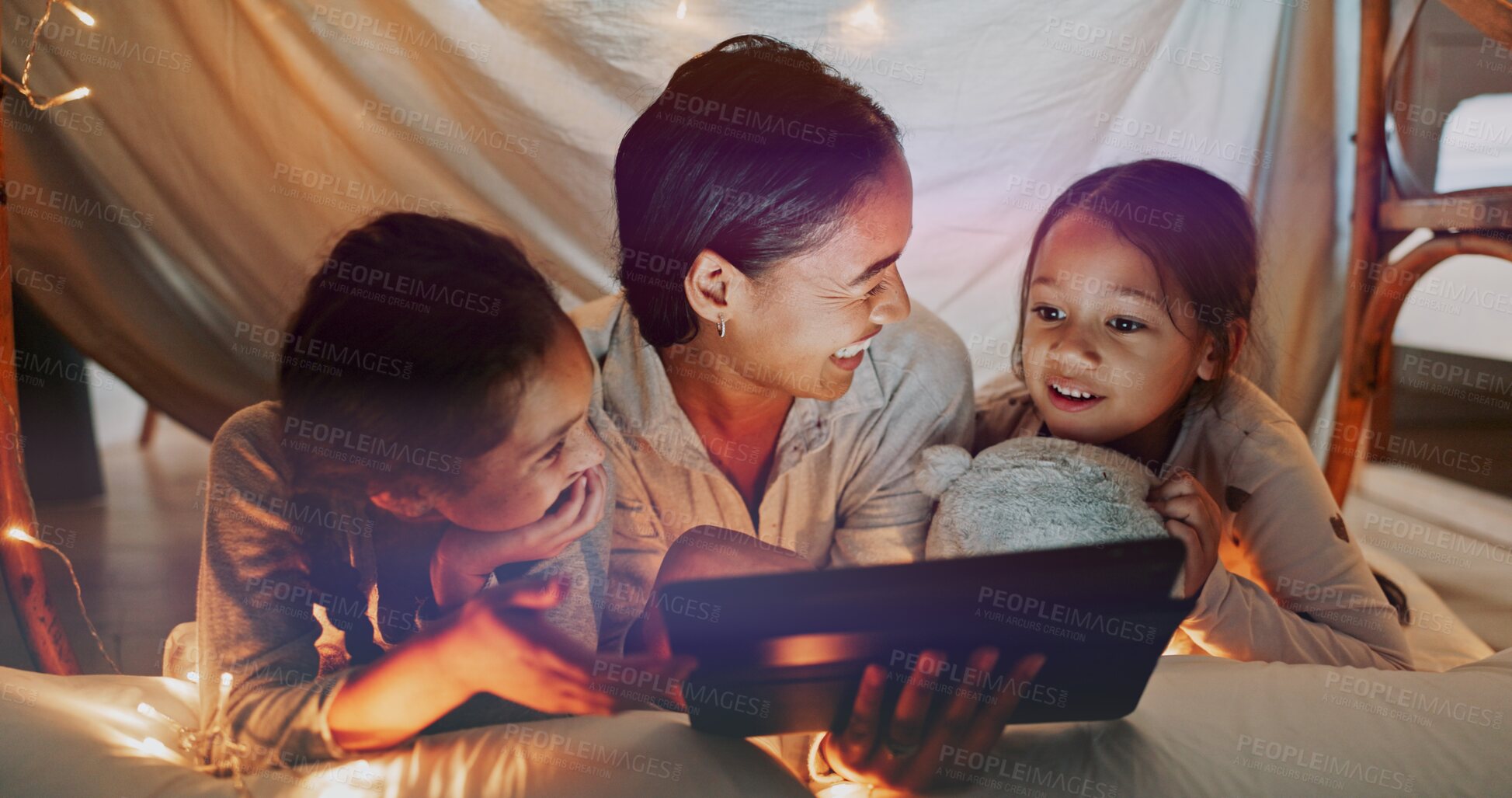 Buy stock photo Reading, night and tablet with family on bed in home together for bonding, love or storytelling. Education, learning or relax with mother and sister kids in bedroom of apartment for child development