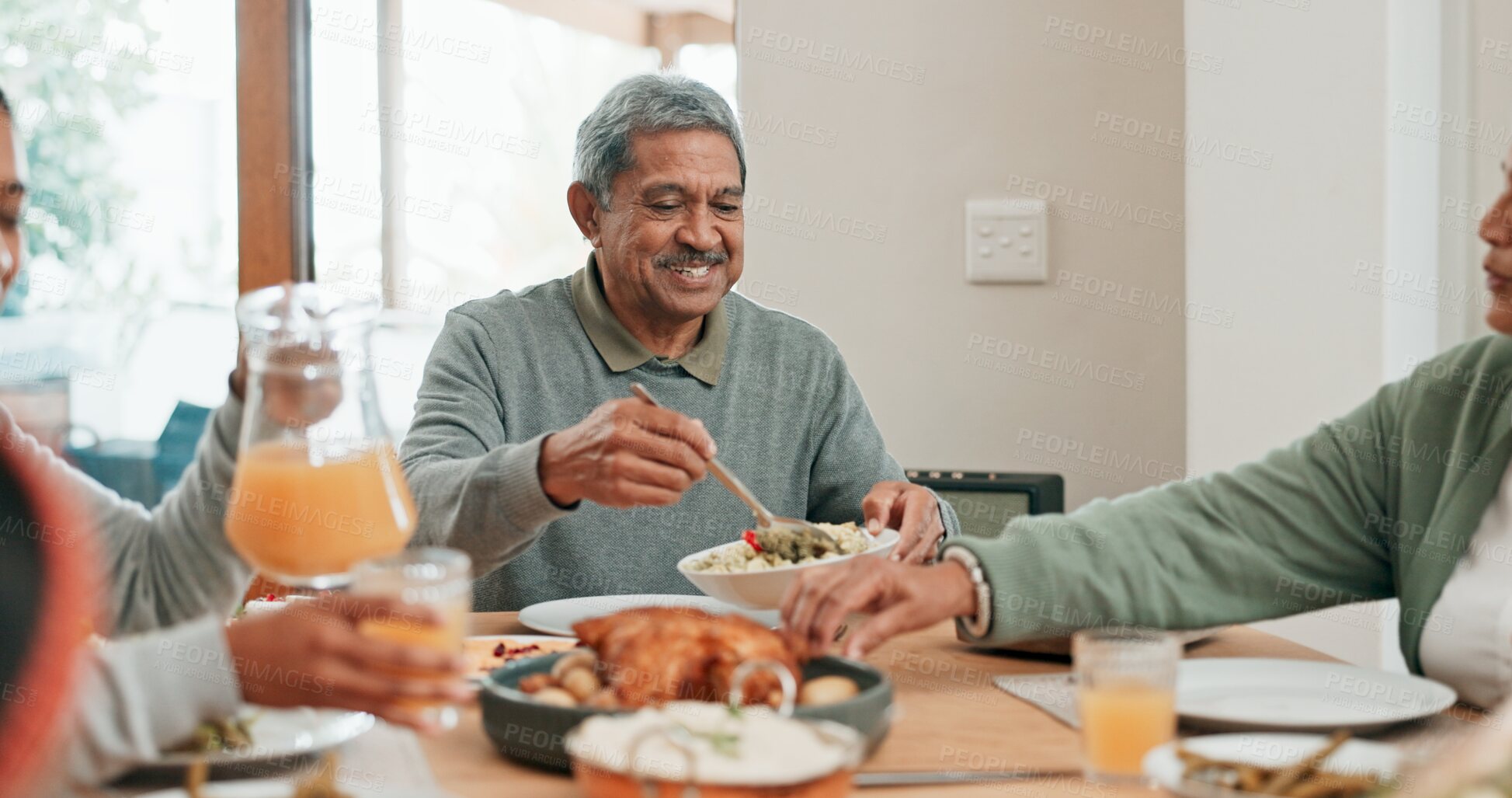 Buy stock photo Senior man, family and lunch with smile, sharing and helping hand for food, care and connection in home. People, eating and happy with meal on table for reunion, holiday or celebration in dining room