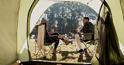 Buy stock photo Camping, couple and outdoor with coffee by tent in morning with conversation, bonding and wilderness getaway. Man, woman and relax together with warm beverage for adventure, back view and peaceful.