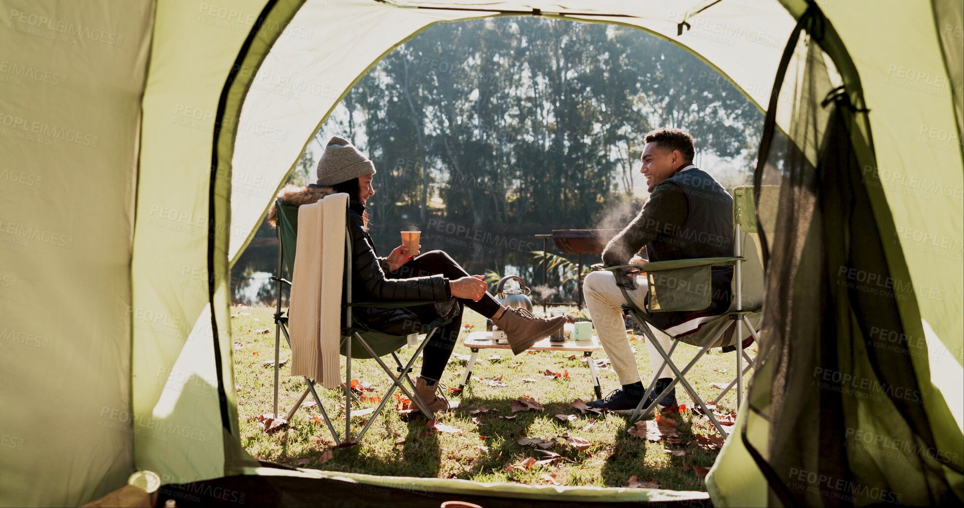 Buy stock photo Camping, couple and outdoor with coffee by tent in morning with conversation, bonding and wilderness getaway. Man, woman and relax together with warm beverage for adventure, back view and peaceful.