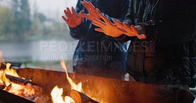 Buy stock photo Friends, hands and fire in outdoor with rain for warm on camp, adventure and winter getaway for holiday. People, together and closeup with bonfire for fireside connection, lakeside and flame.