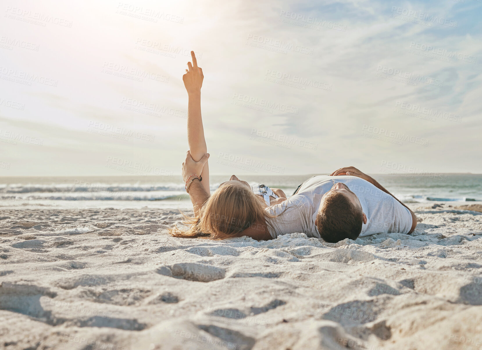 Buy stock photo Couple, relax on sand and pointing on beach for exploring sky, sightseeing and bonding on holiday. People, romance or showing the clouds with tropical adventure, support or commitment in relationship