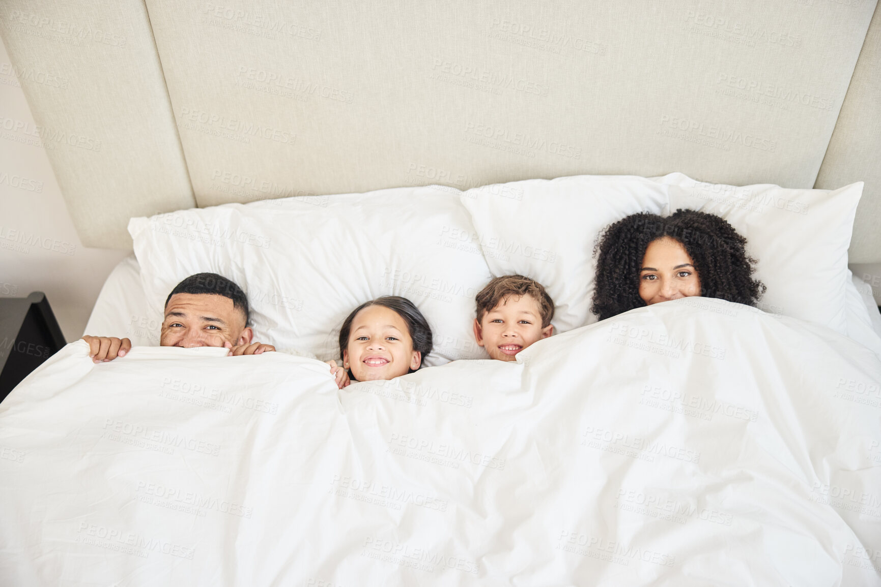 Buy stock photo Family, portrait and hide in home bed with smile for wellness, relationship and trust in morning. Parents, face and children in bedroom for happy, bonding and relax together with support on weekend