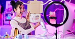 Unboxing, influencer and girl live streaming by phone and ring light for product review, sponsorship or designer brand. Excited streamer with surprise package, sunglasses and online followers at home