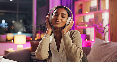 Buy stock photo Headphones, Indian woman and night with dance, music and home with audio subscription. Neon, streaming and smile with happy, relax and chill track in a living room and listening to pop song on sofa