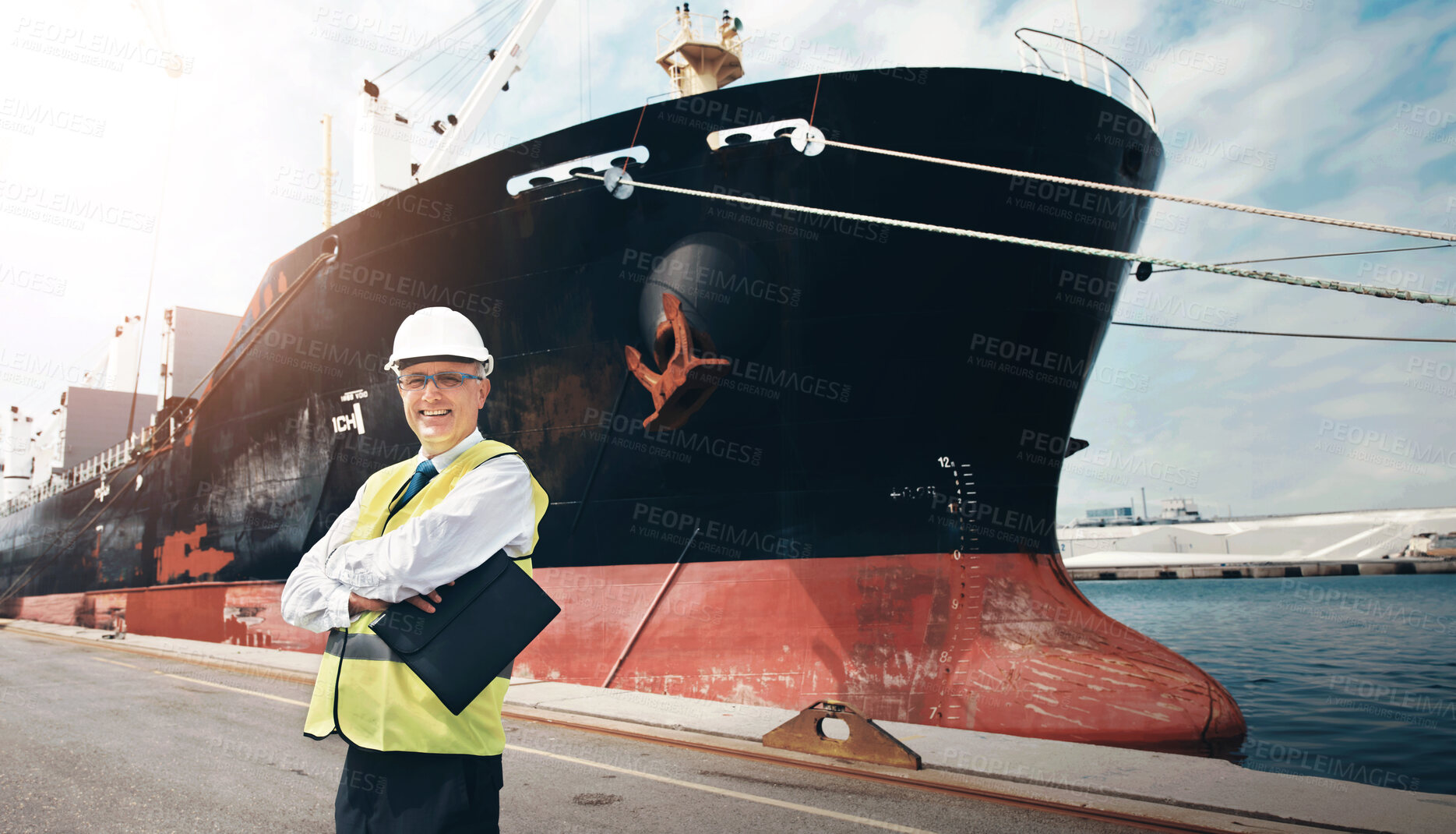 Buy stock photo Mature man, arms crossed and portrait at harbor with smile, pride or career in supply chain management. Person, happy and job in shipping industry with cargo, distribution and helmet in Portugal
