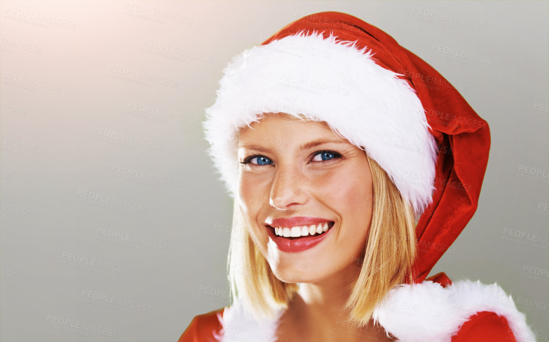 Buy stock photo Cute portrait of a happy young female modeling a red Father Christmas hat with white fur trim, isolated on green - copyspace